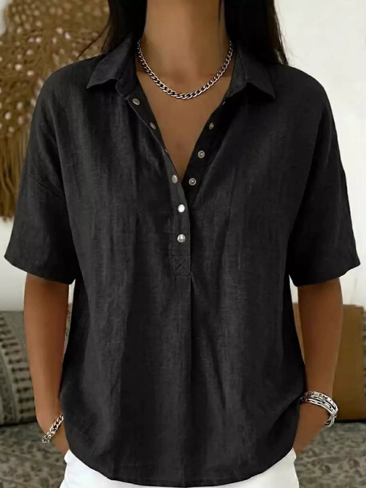 Black short-sleeve snap-front shirt with collared neckline and snap buttons