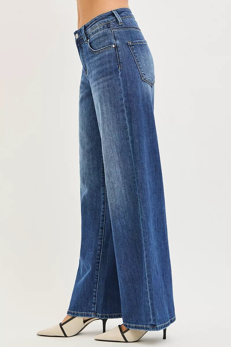 Women’s slouchy baggy jeans, dark blue denim, side view with wide flared hem
