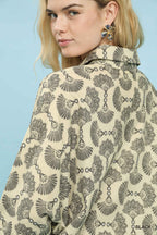 Close-up of printed cotton button-down blouse collar and dark motif pattern