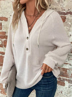 White waffle-knit button hoodie with hood, long sleeves, and curved hem.