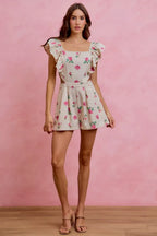 Ivory floral print denim romper with cutout waist and ruffled cap sleeves, front view