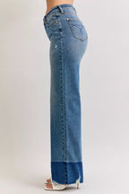 High-waist straight jeans in medium blue denim, side view with raw hem