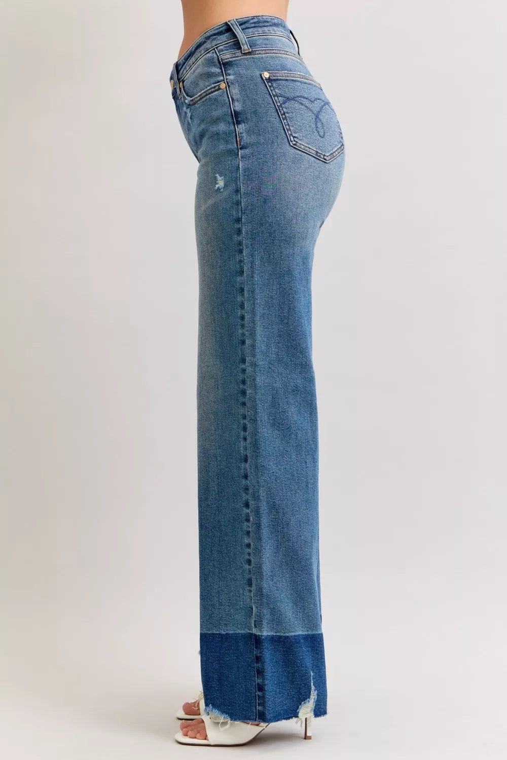 High-waist straight jeans in medium blue denim, side view with raw hem