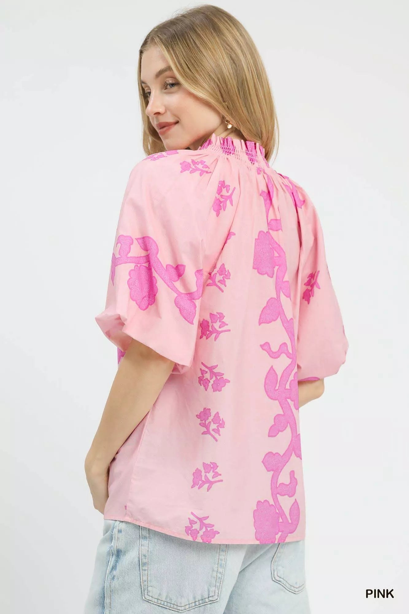Pink floral blouse with smocked neckline and short puff sleeves, back view