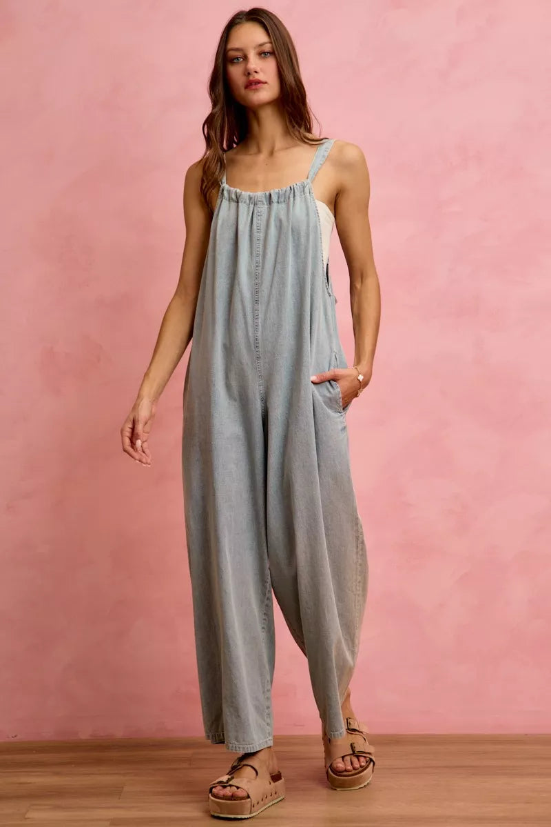 Light blue denim wide-leg overalls with square neckline, thin straps, and front pockets