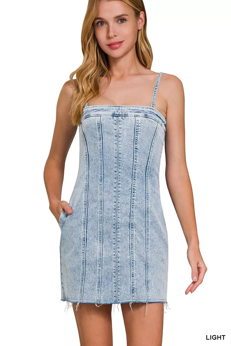 Light wash denim spaghetti strap dress with exposed stitching and frayed hem