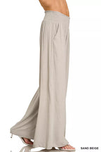 Sand beige wide-leg lounge pants with smocked waistband and long straight legs