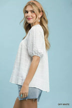 Off-white textured blouse with short puff sleeves and V-neck, side view