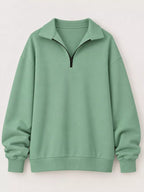 Light green zip-neck sweatshirt with black half-zip and relaxed oversized silhouette