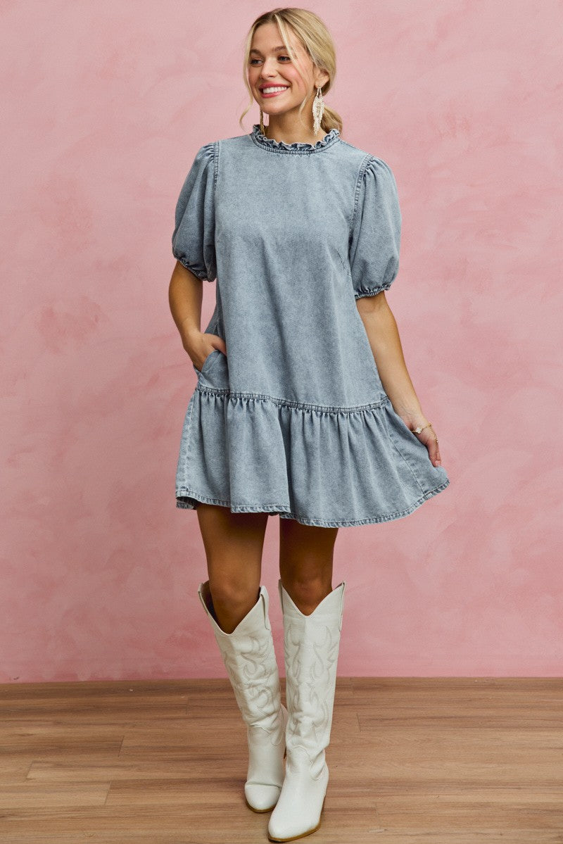 Light-wash denim mini dress with ruffled neckline and puff sleeves, tiered skirt