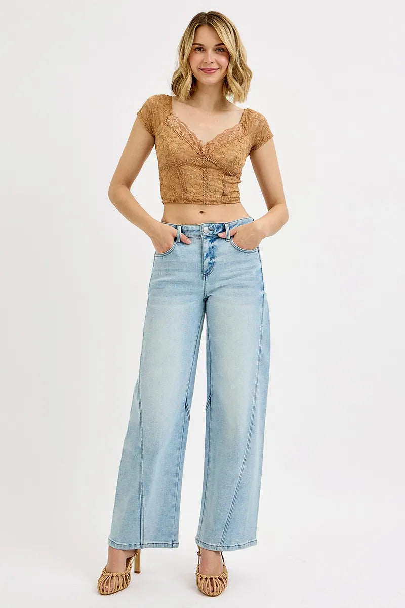 Light wash barrel-fit jeans on model, mid-rise waist with button closure and wide legs
