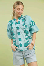 Women's teal cotton blouse with smocked neckline, floral print, short puff sleeves