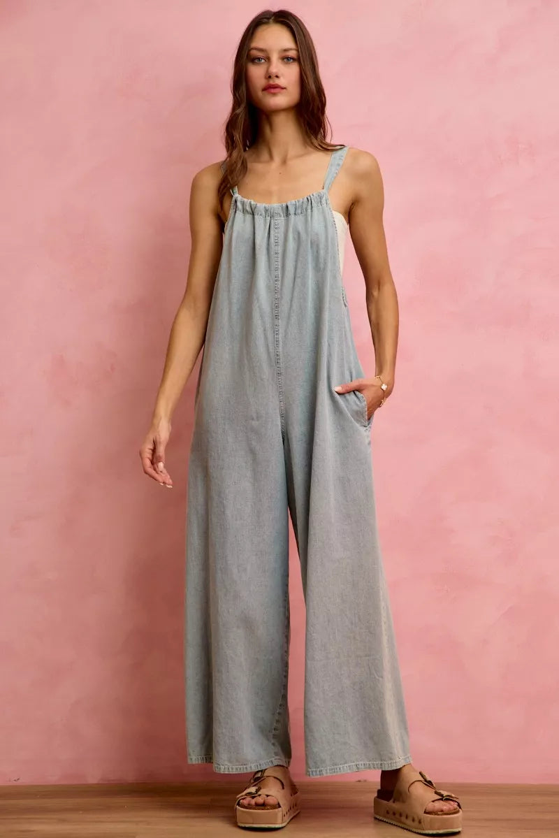 Light blue denim wide-leg overalls with gathered bodice and wide, flowing legs