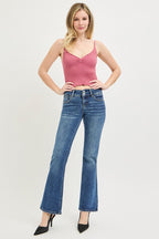 Medium wash low rise bootcut jeans on model with belt loops and front button closure