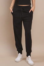 High-waisted black joggers with drawstring waist and tapered ankle cuffs, side pockets