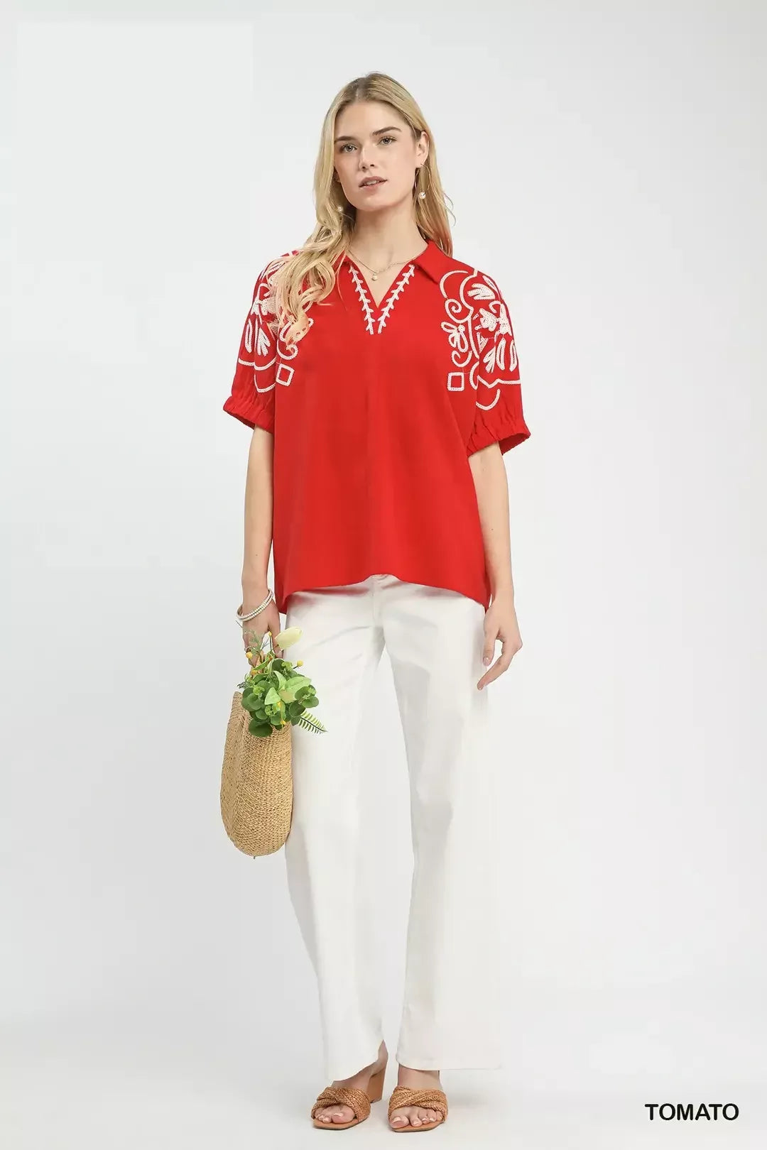 Red embroidered blouse with short sleeves and V-neck, worn over white pants.