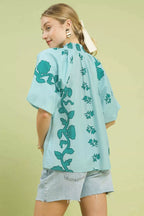 Women's teal floral cotton blouse with flutter sleeves and smocked yoke detail