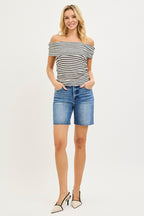 Medium-wash high-rise denim shorts with raw hem, five-pocket design.