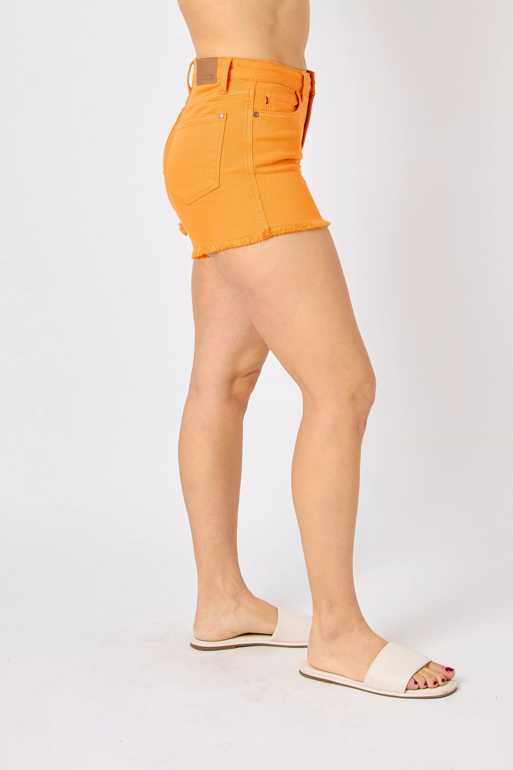 Orange denim shorts with back patch pockets and raw frayed hem