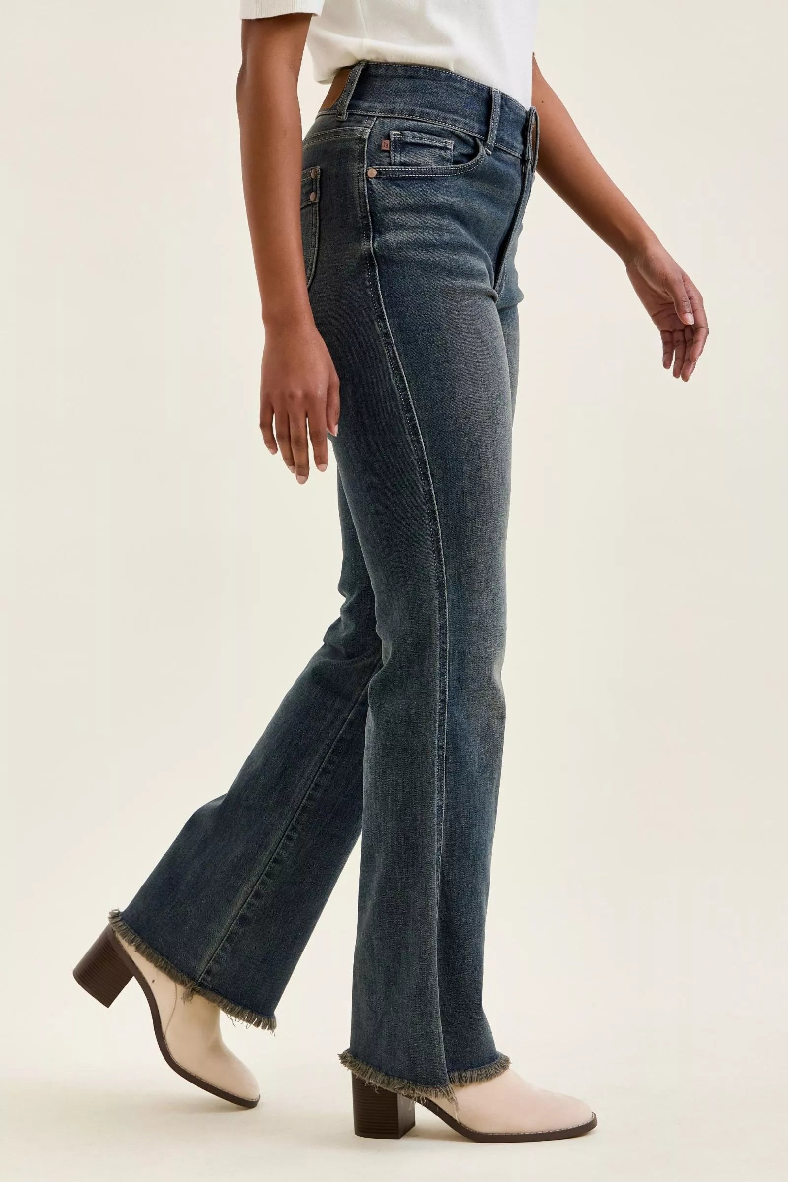 High-waist straight dark blue jeans with frayed hem and front patch details