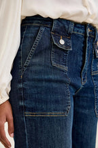 Women’s dark blue denim utility jeans with large front patch pocket and topstitching