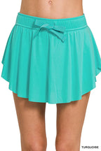 Turquoise tennis skort with elastic waistband and ruffle hem, bow-tie detail