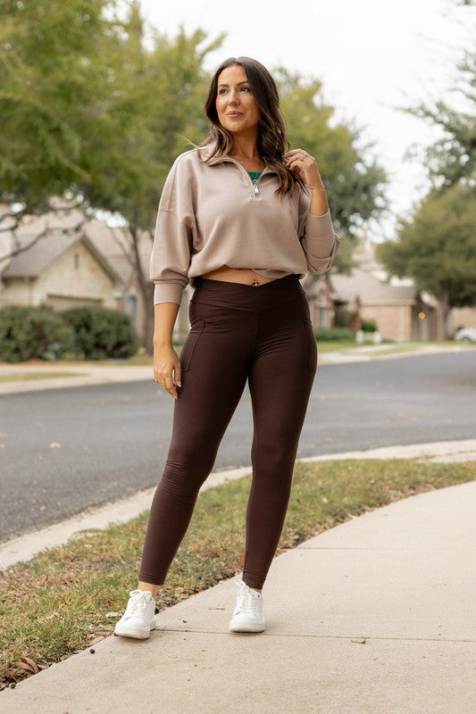 Brown full-length yoga leggings with crossover waistband and side pockets
