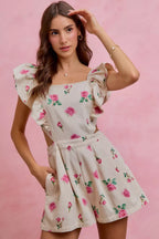 Ivory floral print denim romper with ruffled sleeves and flared skirt with pleated waist