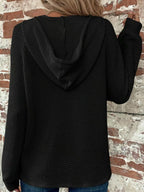 Black waffle-knit button hoodie with hood and long sleeves, back view