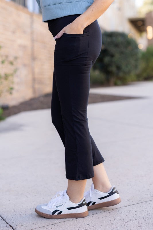 Black kick flare leggings with pockets, side view of flared leg
