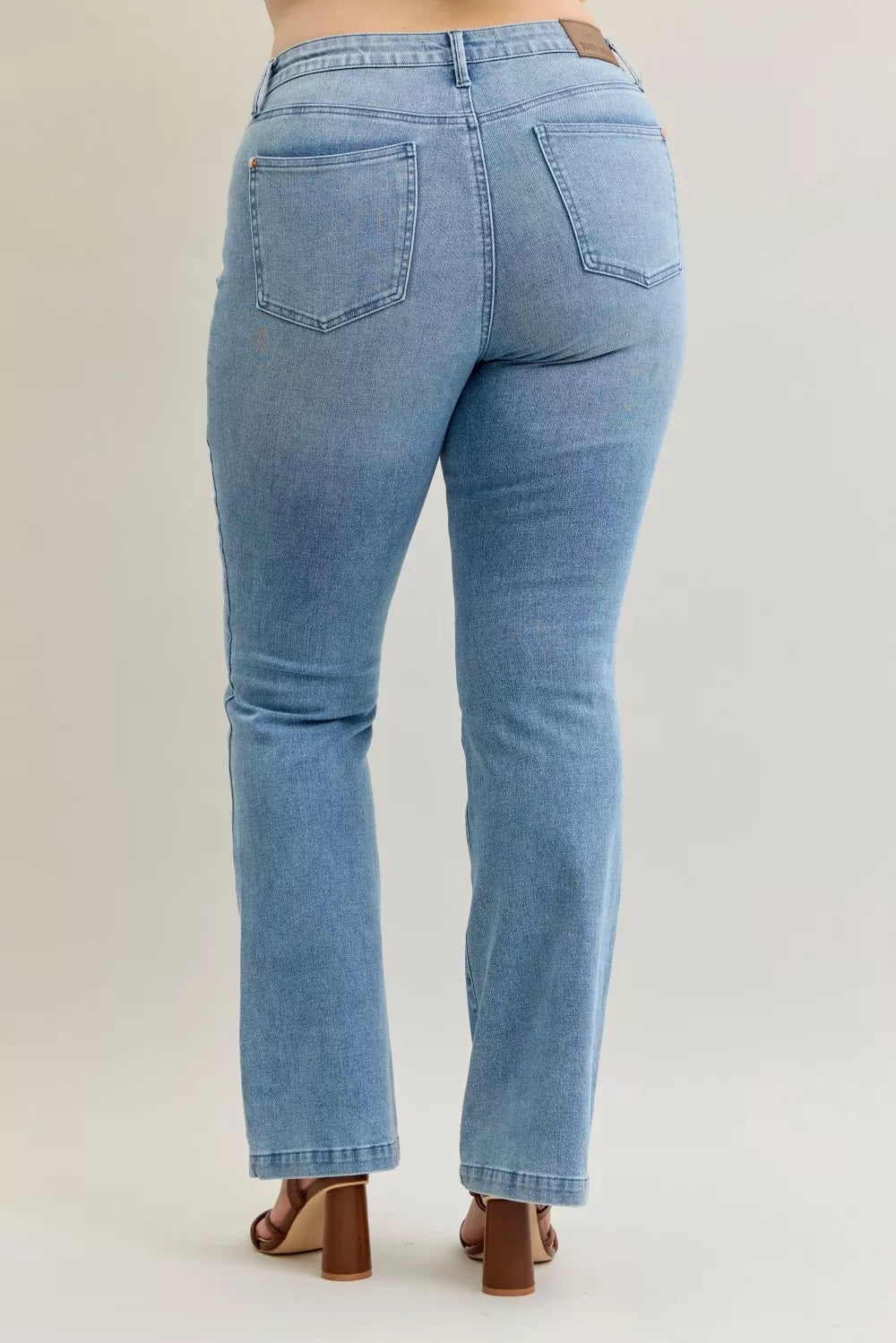 Light blue mid-rise bootcut jeans with back patch pockets and clean stitched waistband