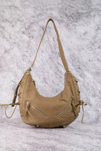 Tan crescent shoulder bag with double straps, zip pocket, and side tie tassels