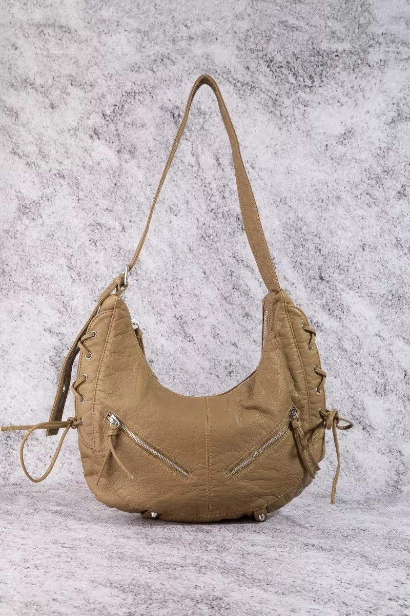 Tan crescent shoulder bag with double straps, zip pocket, and side tie tassels