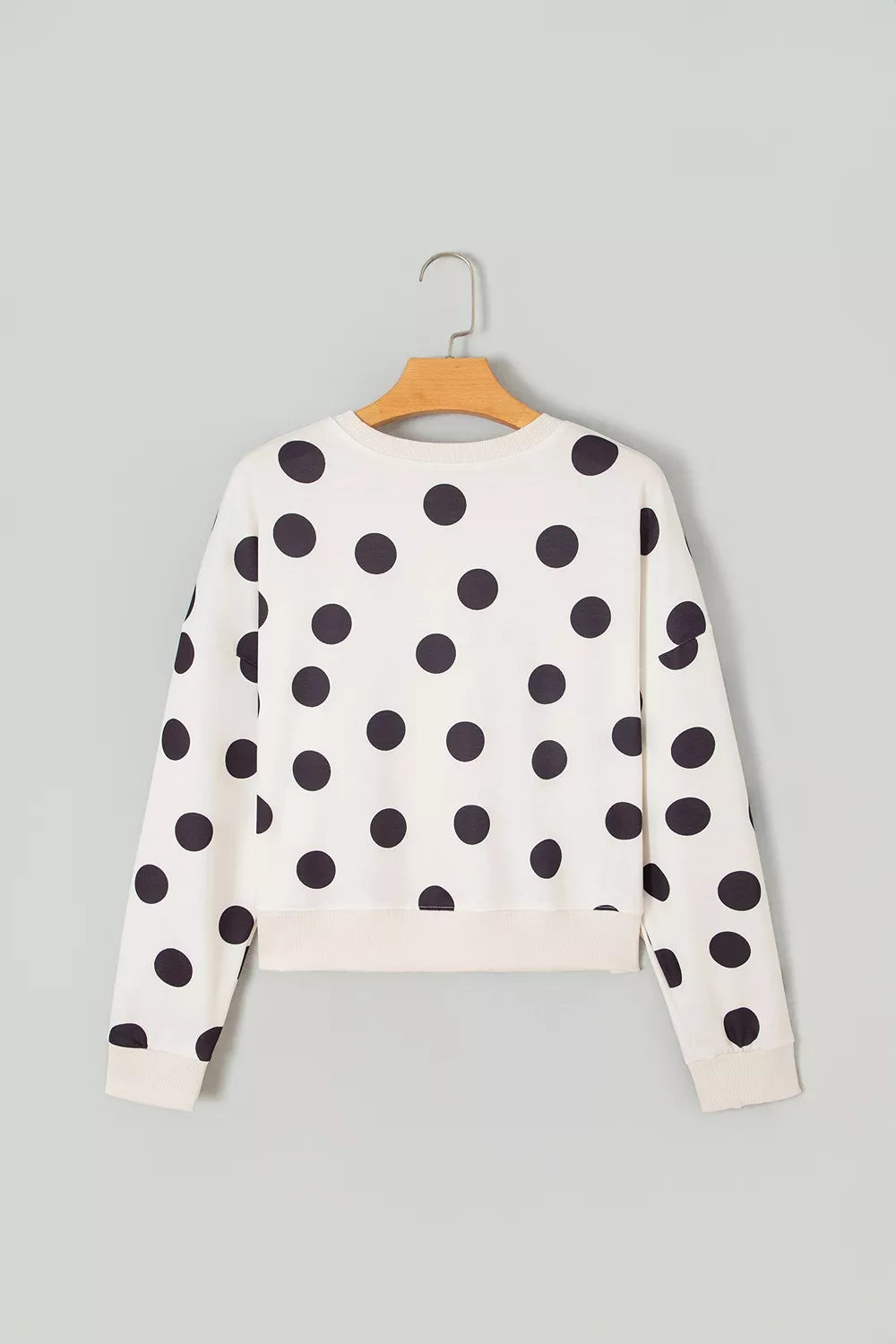 White kids’ sweatshirt back view with black polka dots; long sleeves and crew neck