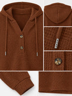 Caramel waffle-knit hoodie close-up: hood, two-button front, and drawstring ties
