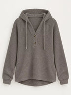 Gray waffle-knit button hoodie with hood, gold buttons, and drawstring ties.