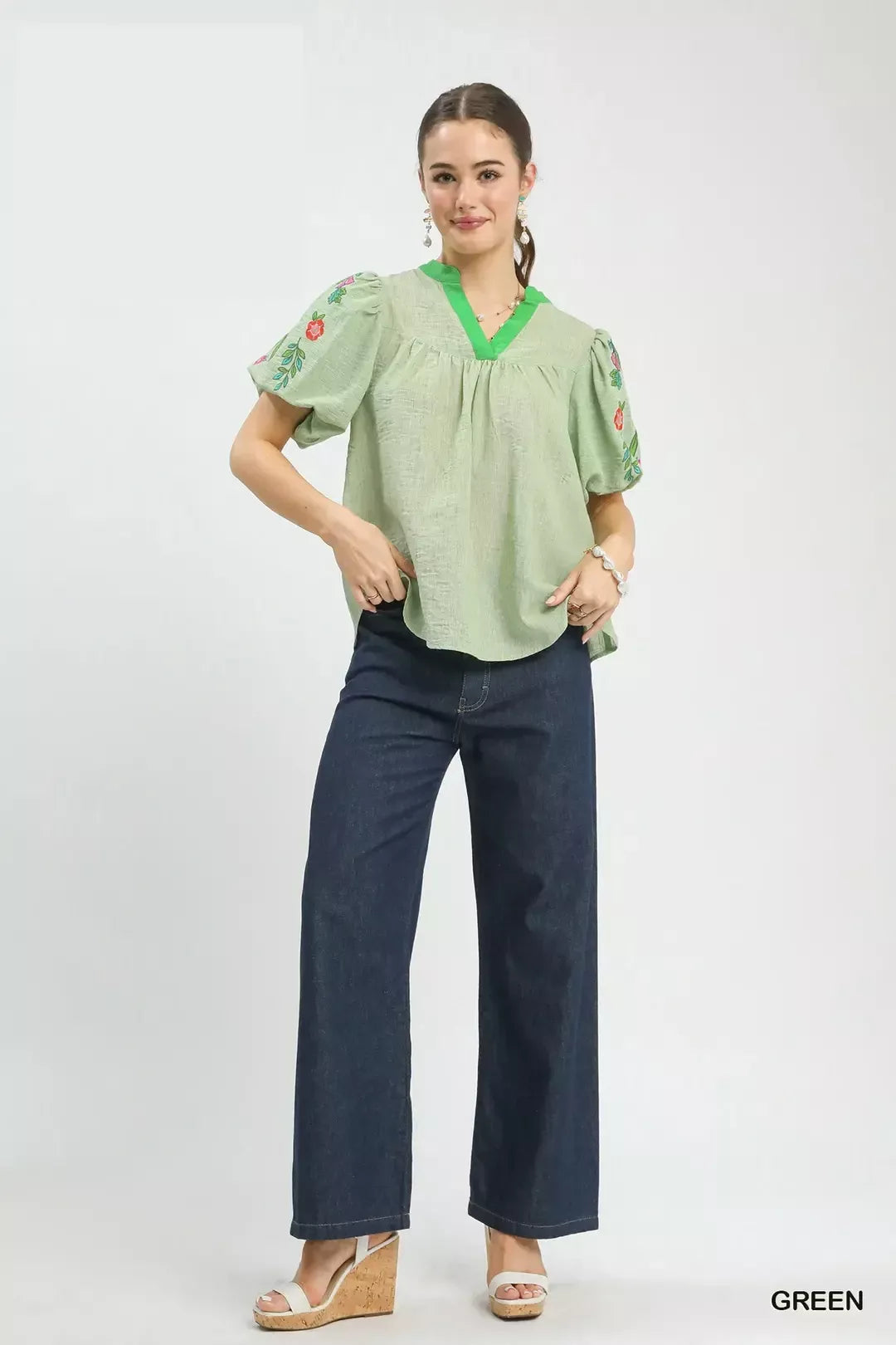 Light green puff-sleeve V-neck top worn with dark blue cropped pants