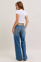 Women’s mid-rise straight jeans in blue denim with tan corduroy waistband, back angle view