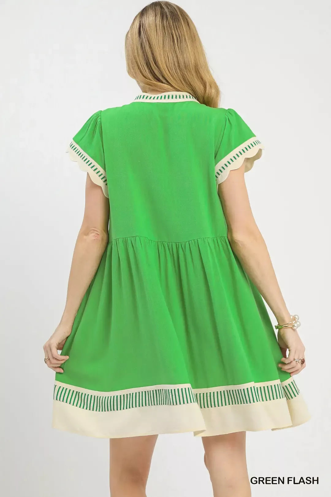 Back view of green flutter sleeve linen dress with gathered skirt and striped hem