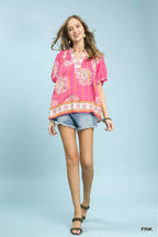 Pink floral V-neck blouse with puff sleeves and border print at hem