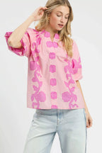 Pink floral blouse with smocked yoke, notched collar, and short puff sleeves