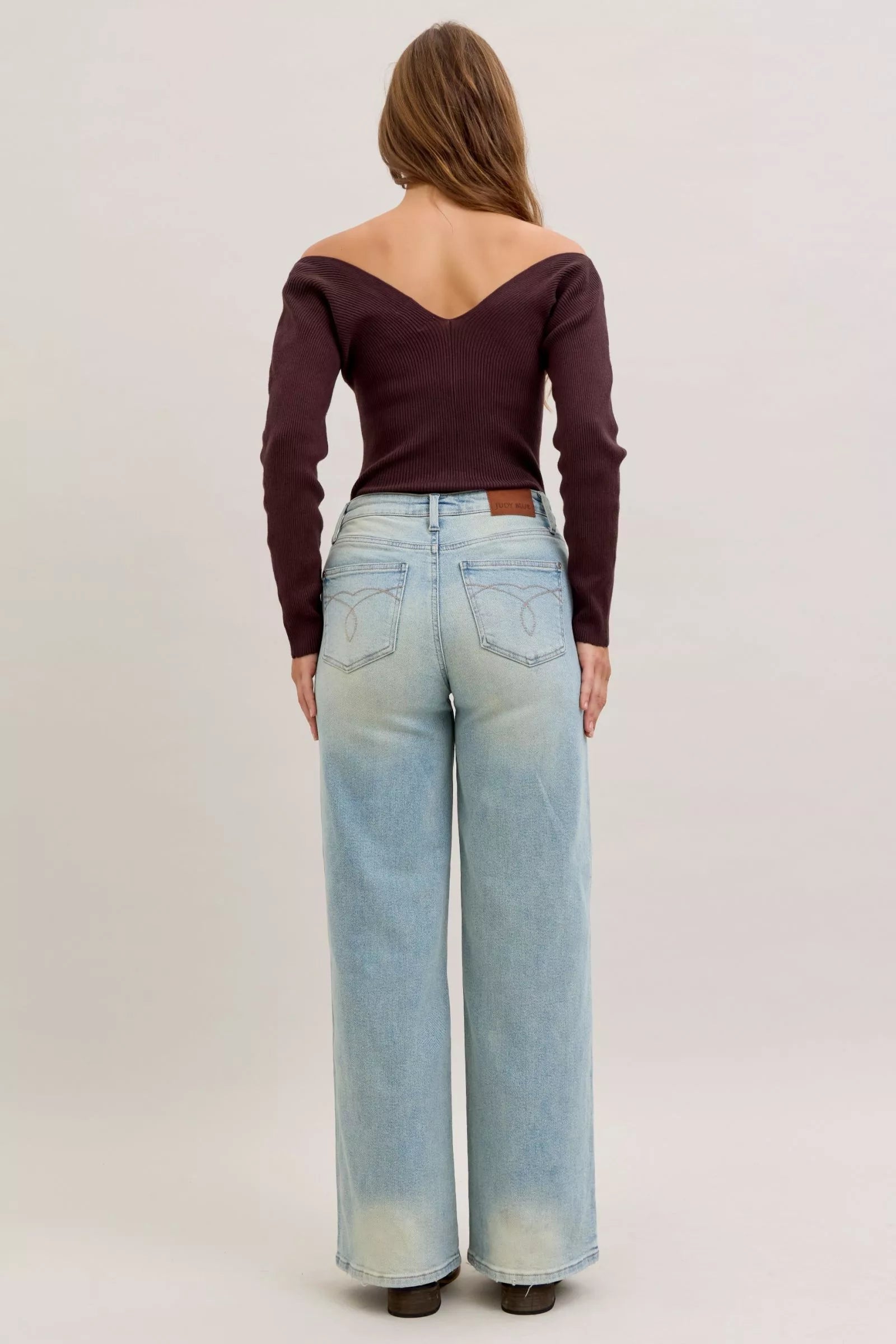 Light blue high-waist straight jeans back view with patch pockets and waistband button