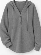 Gray waffle-knit button hoodie detail with hood drawstrings and three front buttons