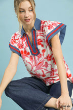 Flutter top close-up front, pink-and-white floral print with red blossoms and navy trim