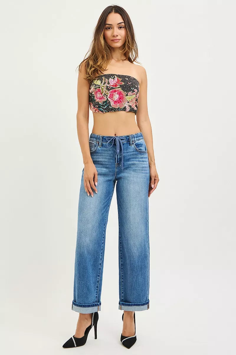 Medium-wash elastic waist cuffed ankle jeans on model, front view