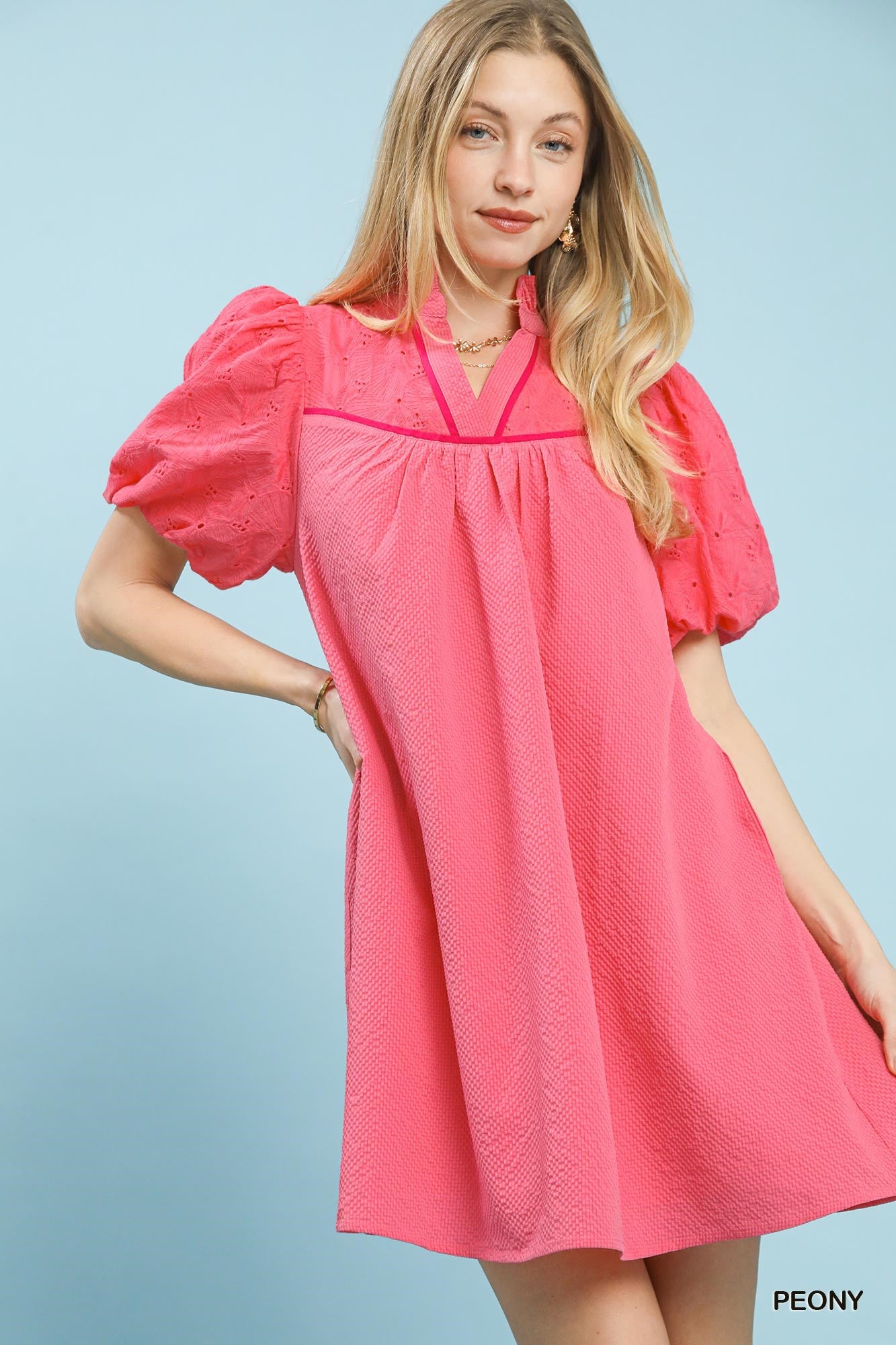 Pink textured eyelet babydoll mini dress with V neckline and short puff sleeves