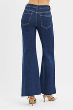 Back view high-rise wide flare jeans, blue denim with back yoke and flap pockets