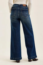 Dark indigo wide-leg jeans with rear patch pockets and stitched waistband