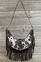 Cow print faux leather fringe hobo bag, black strap, centered metal buckle detail