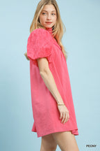 Pink textured eyelet babydoll mini dress with short puff sleeves and straight hem